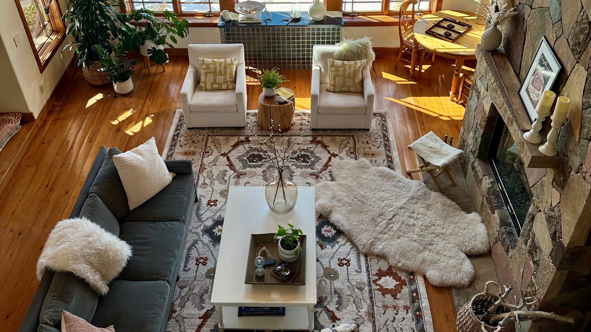 patterned, floral area rug in living area with sectional and stone fireplace